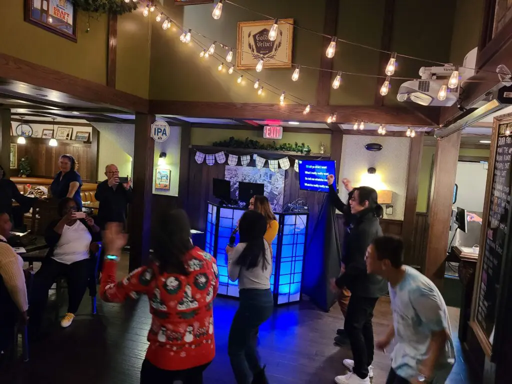 Karaoke guests sing with Mr Dj Services - Mr Dj Services People sing with the karaoke dj and dance at the Golden Road Brewery Christmas party with a photo booth