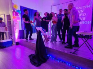 Client and guests sing together using karaoke dj package with up lights and party dj music for a birthday splash.
