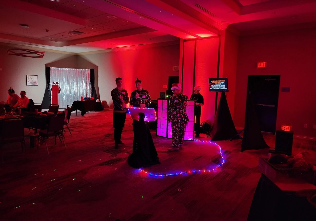 Karaoke Dj, Client staff test out microphones, photo booth with the up lights in a dimly lit room